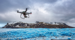 A drone flying over glacier reaching towards a mountain